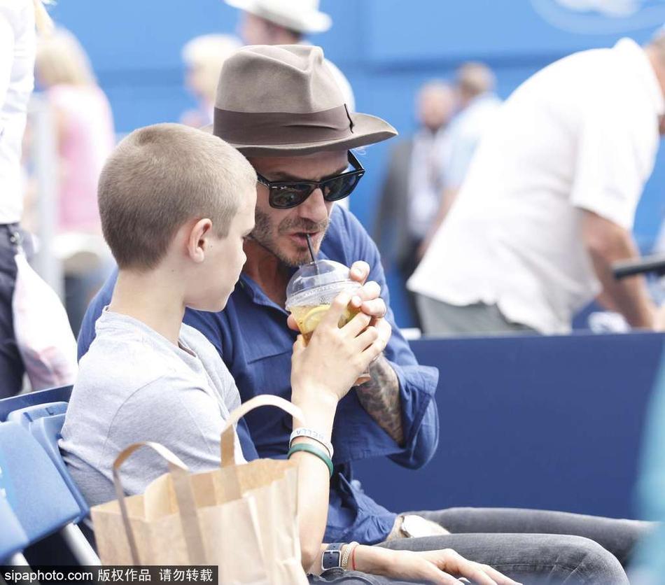 当地时间2017年6月22日，英国伦敦，贝克汉姆带儿子罗密欧现身观战网球赛，抢儿子饮料喝。