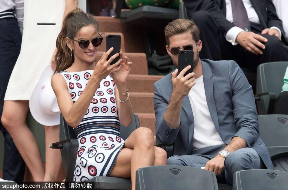 当地时间2017年6月12日，法国巴黎，“法甲第一帅”凯文·特拉普（Kevin Trapp）携超模女友伊莎贝尔·戈勒（Izabel Goulart）观战法网，二人同时拿起手机自拍默契十足。
