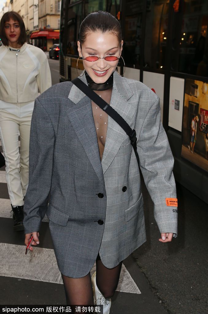 当地时间2018年1月17日，法国巴黎，超模贝拉·哈迪德（Bella Hadid）现身街头，她穿拼接灰色格纹西服配黑丝，大玩下体失踪秀诱惑。