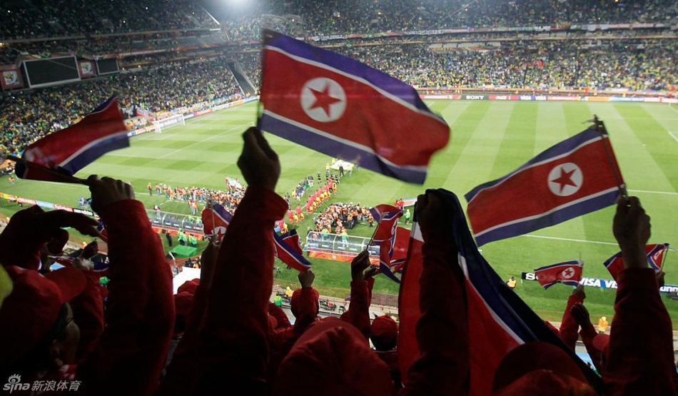 2010年世界杯小组赛，朝鲜对阵巴西，看台上的朝鲜支持者挥动国旗。