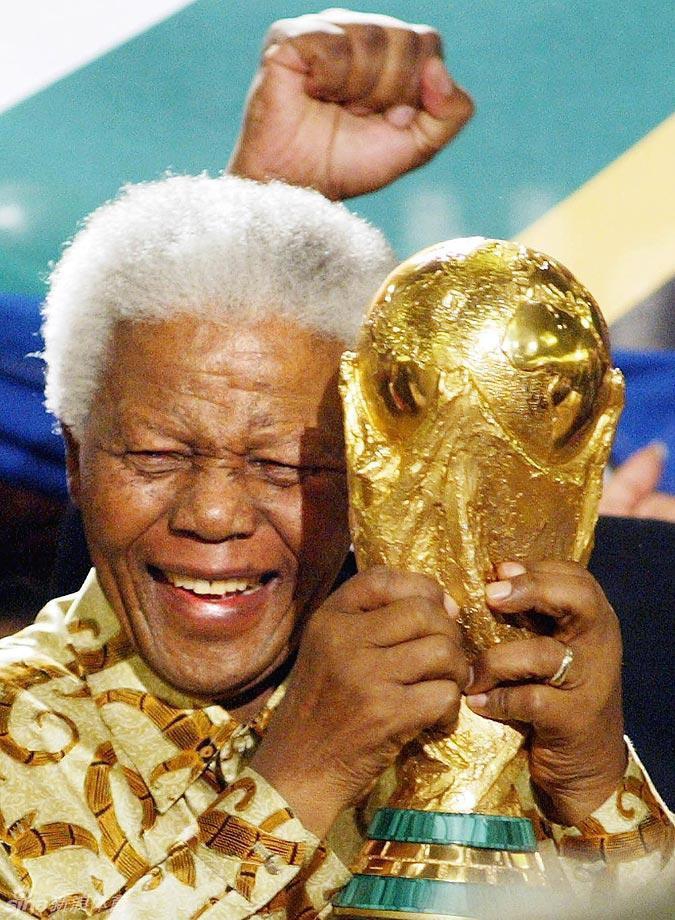 2004年瑞士苏黎世，南非成功申办2010年世界杯，曼德拉举起世界杯冠军奖杯。