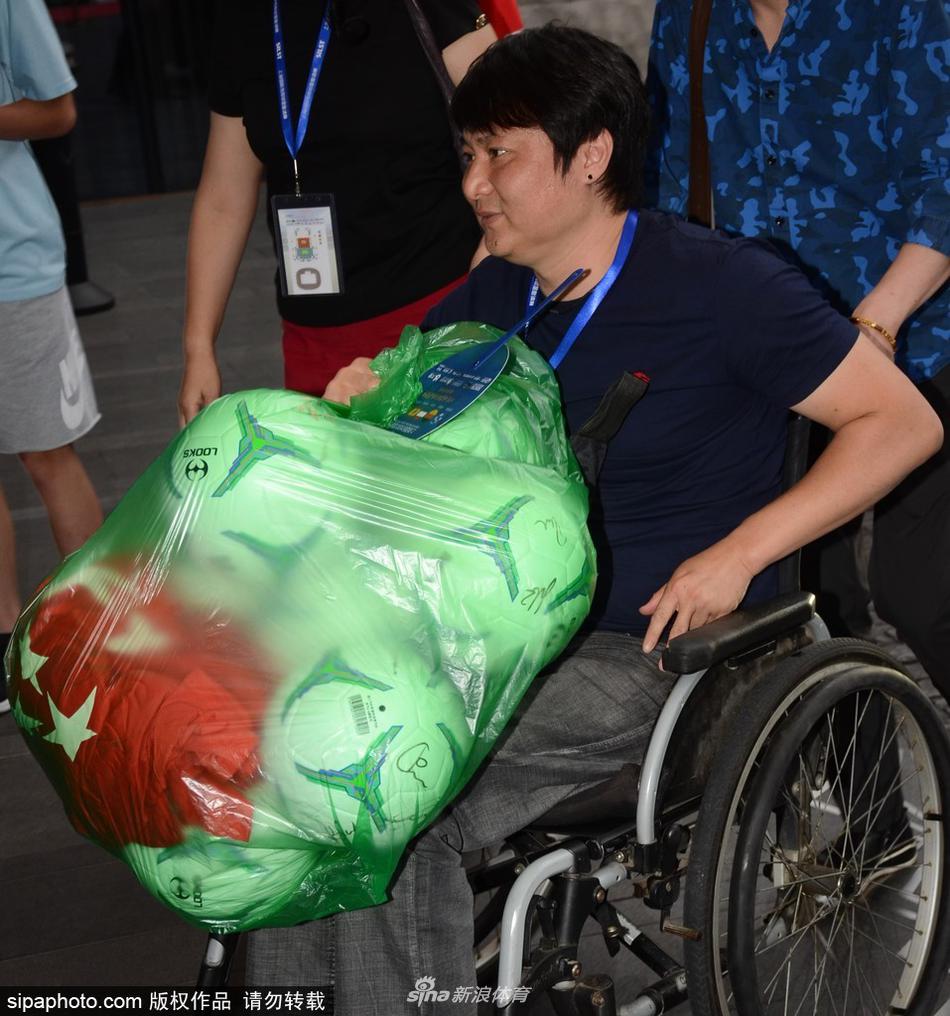 2018年6月3日，上海，前辽足球员曲乐恒获家人陪同推轮椅现身酒店，怀抱足球心情大好，亲切与球迷合影。