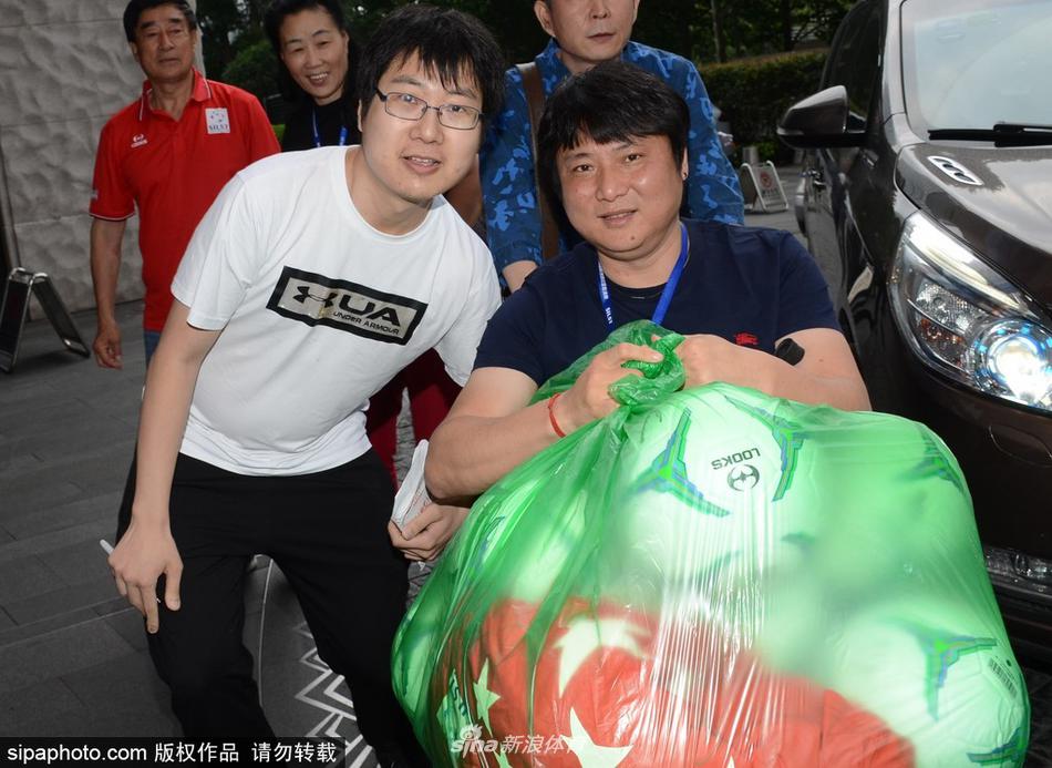 2018年6月3日，上海，前辽足球员曲乐恒获家人陪同推轮椅现身酒店，怀抱足球心情大好，亲切与球迷合影。